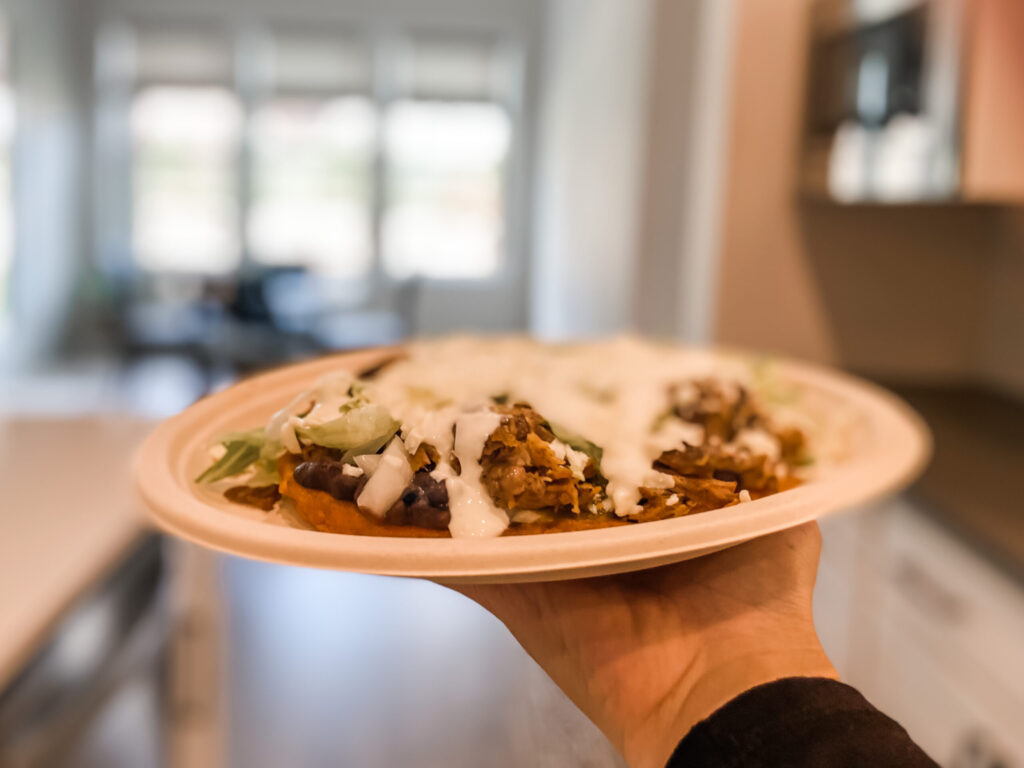 a gluten-friendly sope with shredded is topped with cheese, sour cream, lettuce, and salsa